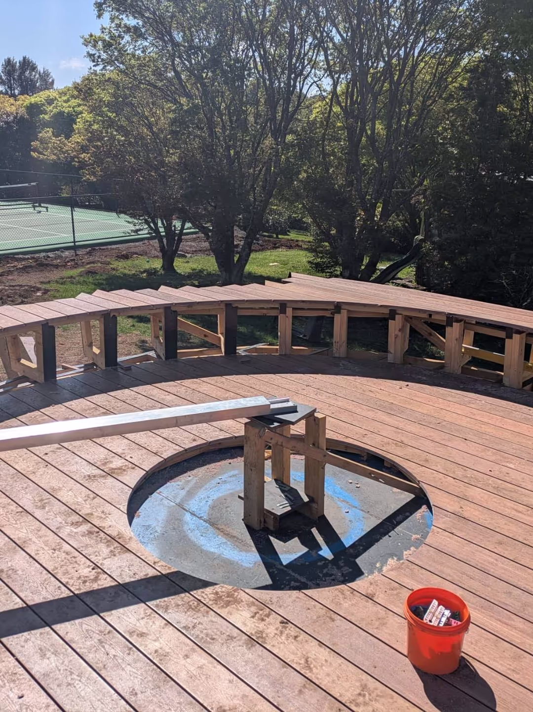 Curved bench seating under construction around the fire pit